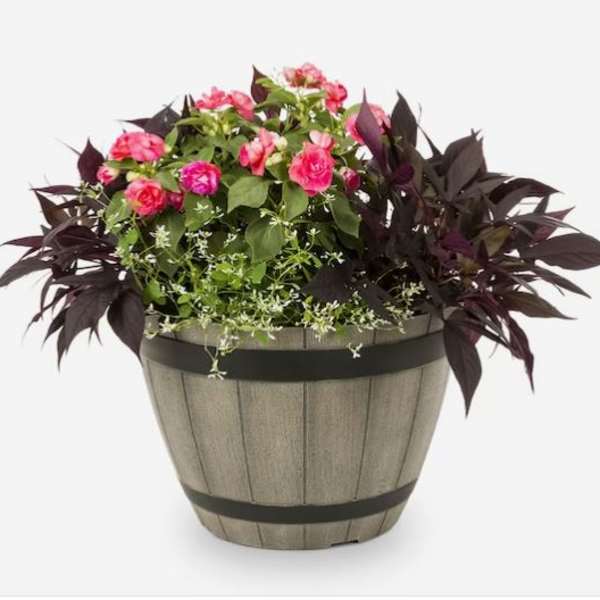 Pink flowers arranged in a wooden barrel planter