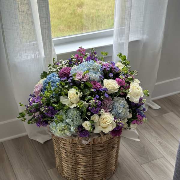 Large mixed flower arrangement in a woven basket