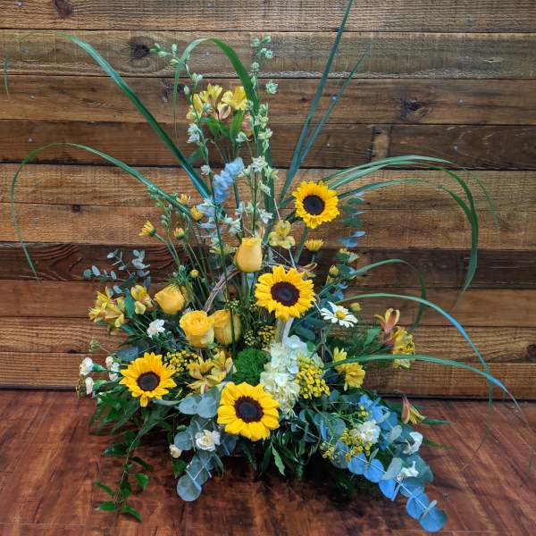 Tall floral arrangement with sunflowers and yellow roses