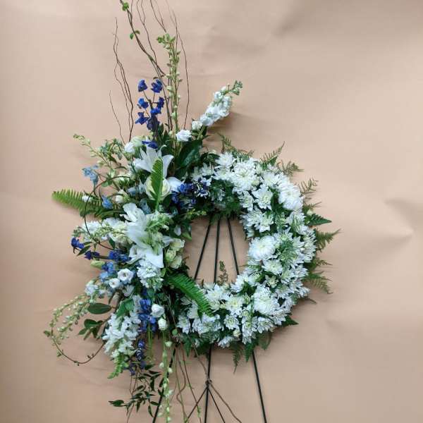 White and blue floral wreath on a black easel
