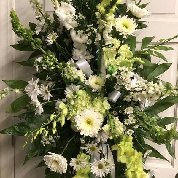 Tall white and lime-green floral standing spray on an easel