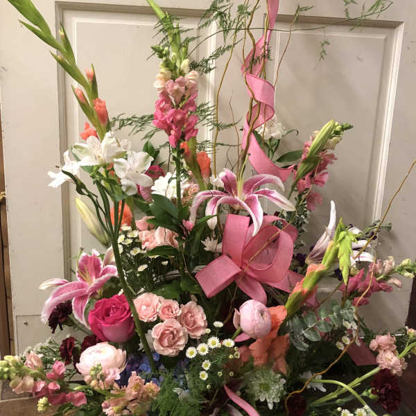 Tall mixed flower basket with pink ribbon and butterfly topper