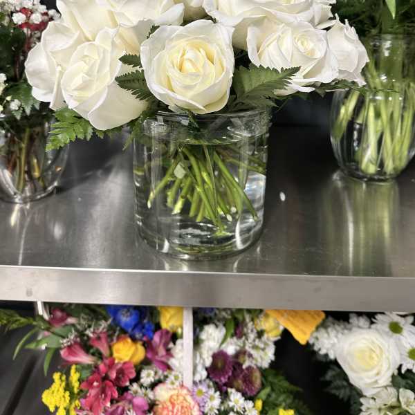 White roses arranged in a clear glass vase