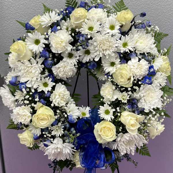 Heart-shaped floral wreath with white roses, daisies, and blue flowers
