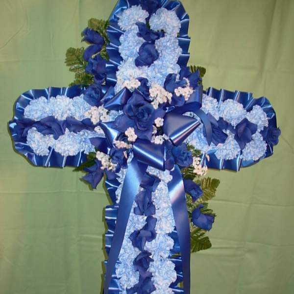 Blue and white floral cross on a stand with ribbon accents