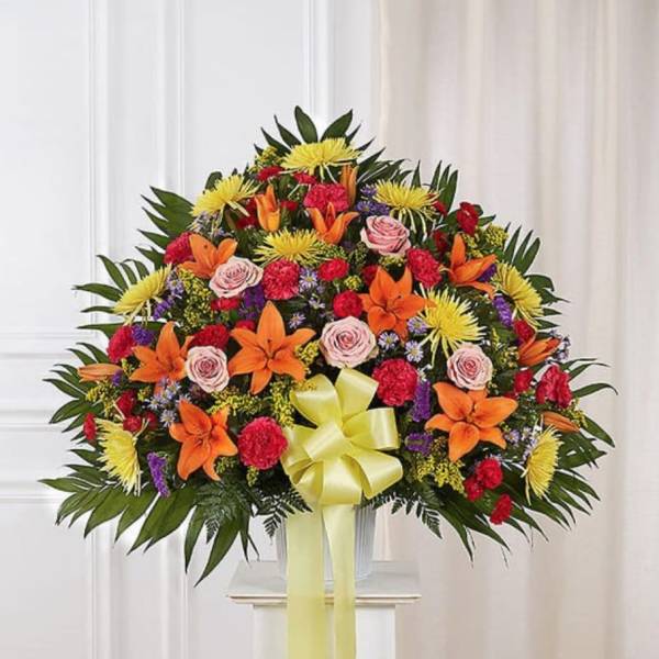 Large mixed floral spray with orange lilies, pink roses, and yellow blooms