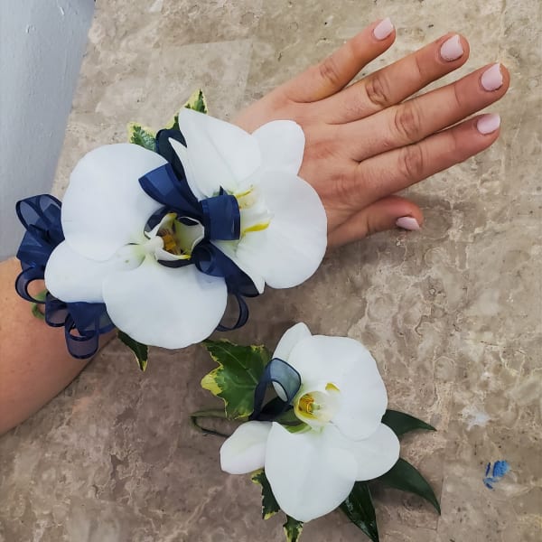White orchid corsage and boutonniere with navy ribbon accents