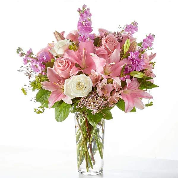 Pink and white bouquet of roses and lilies in a clear glass vase