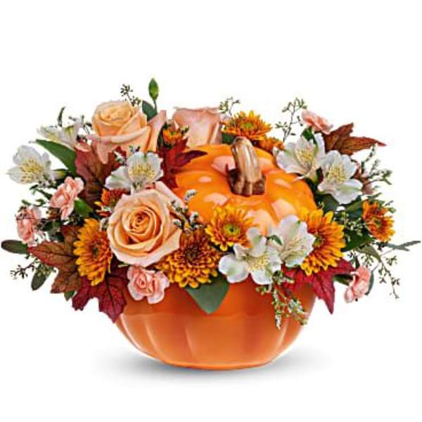 Pumpkin-shaped vase with peach roses and autumn flowers