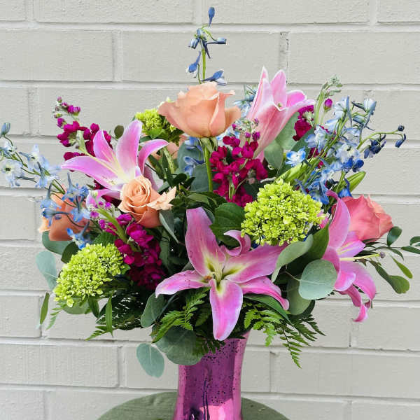 Pink lilies and roses in a metallic pink vase