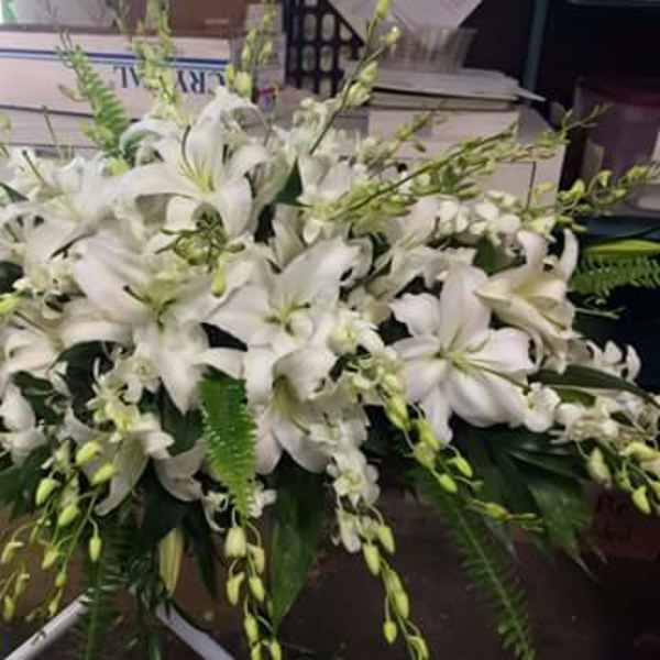 Large white lily arrangement with cascading greenery