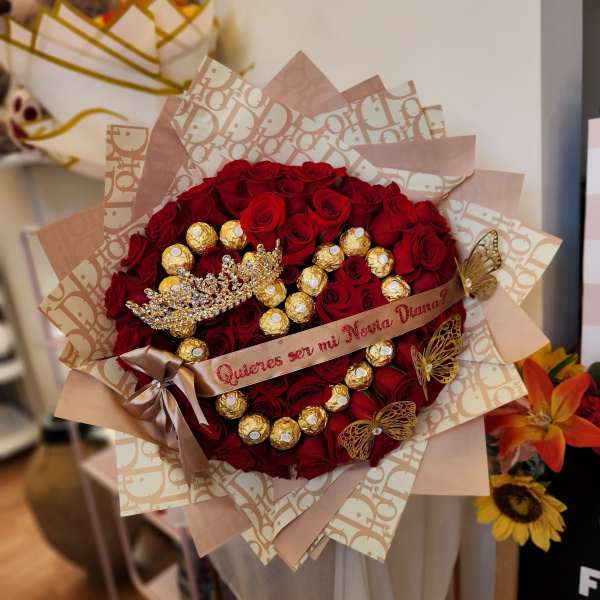 Bouquet of red roses with gold-wrapped chocolates and a decorative ribbon