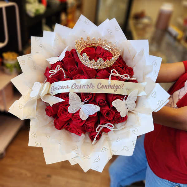 Bouquet of red roses with white butterfly decorations and a gold crown