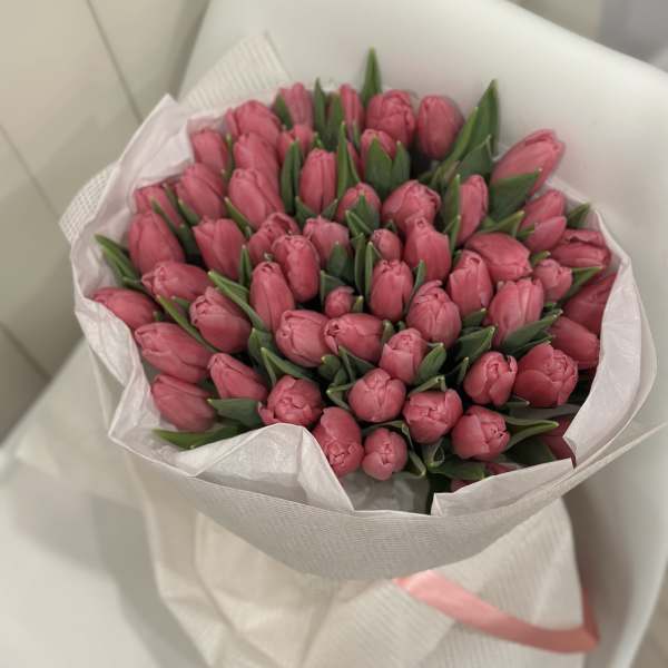 Bouquet of pink tulips wrapped in white paper