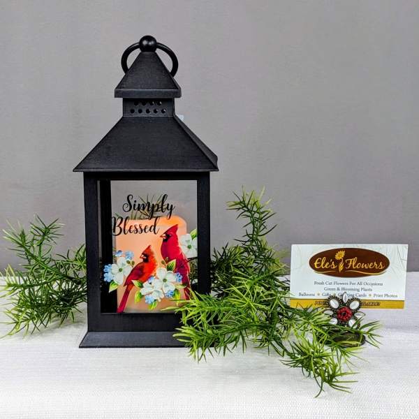 Black lantern with a "Simply Blessed" card and faux greenery.