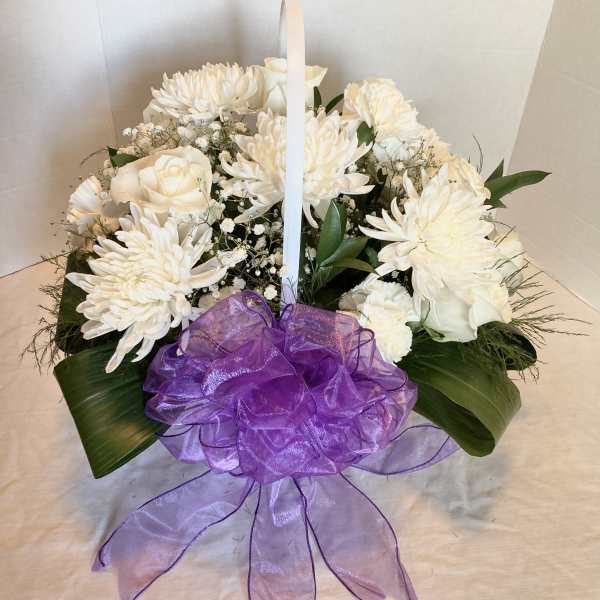 White floral basket arrangement with a purple ribbon bow