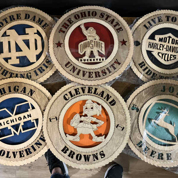 Six round collegiate logo plaques with team names and mascots