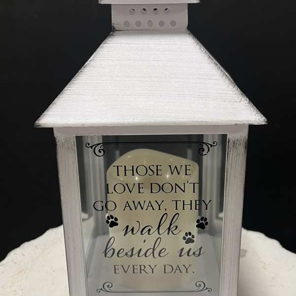 White memorial lantern with a sympathy quote and paw prints