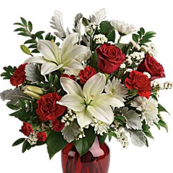 Red roses and white lilies arranged in a red glass vase