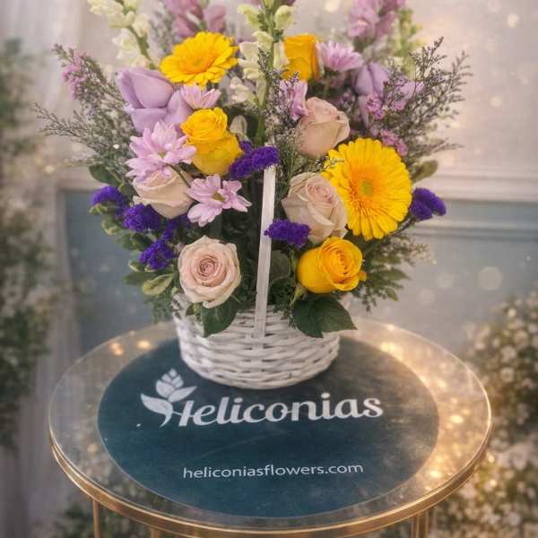 Basket arrangement with yellow gerberas, roses, and lavender flowers