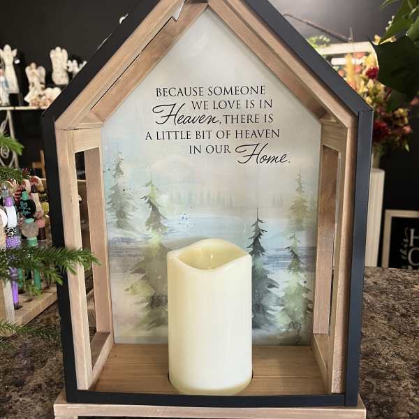 House-shaped memorial sign with a candle and sympathy message