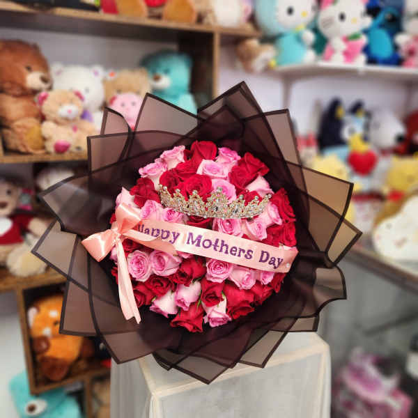 Bouquet of red and pink roses with a crown and Mother's Day ribbon