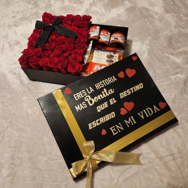 Box of red roses with chocolates and a black gift lid with gold lettering