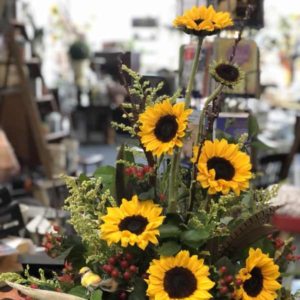 Sunflower arrangement with berries and antlers in a rustic container