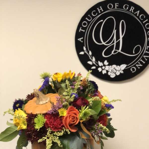 Autumn floral arrangement in a pumpkin container with mixed blooms
