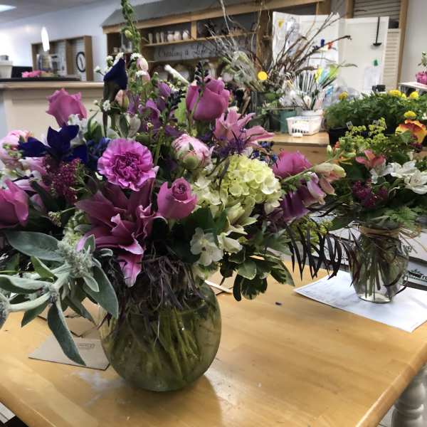 Large mixed bouquet of pink and purple flowers in a glass vase