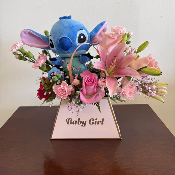 Pink lily and rose arrangement with blue plush toy in a Baby Girl box.