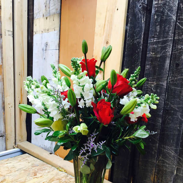Red roses and white snapdragons in a clear glass vase