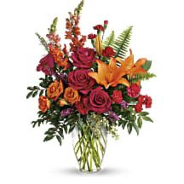 Bouquet of red and orange roses with lilies in a glass vase