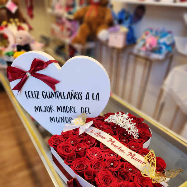 Heart-shaped box of red roses with a birthday message card and ribbon