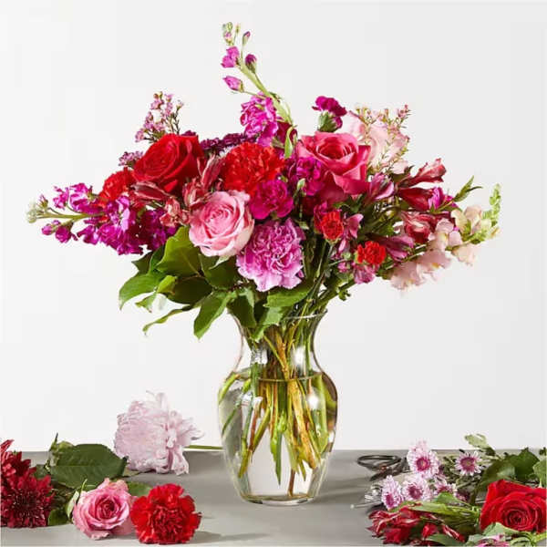 Mixed pink and red flower bouquet in a clear glass vase