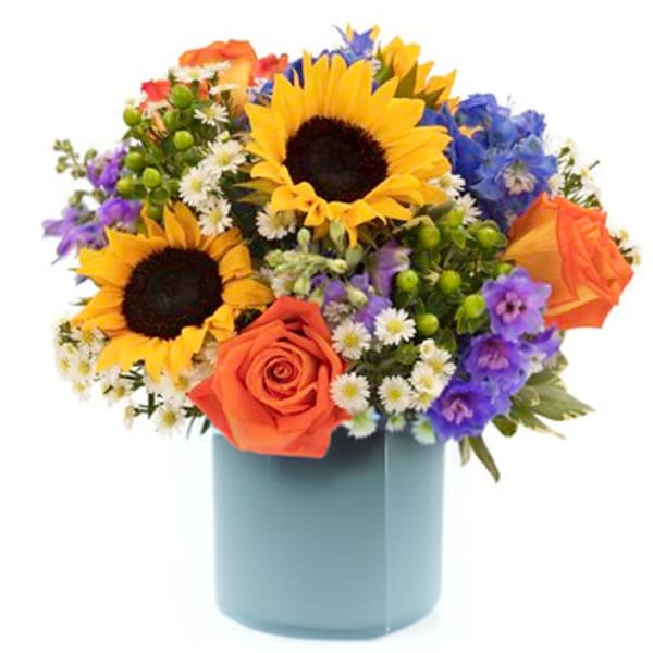 Mixed bouquet with sunflowers, orange roses, and purple flowers in a blue vase