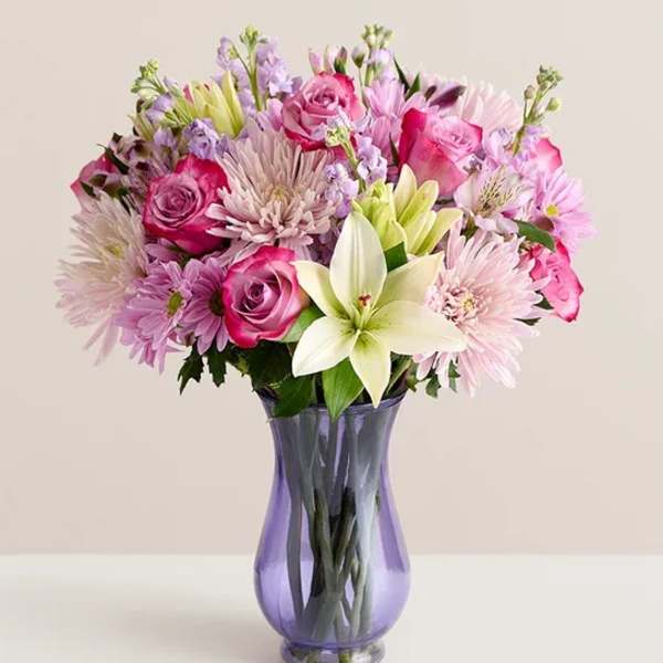 Pink and lavender mixed bouquet in a purple glass vase