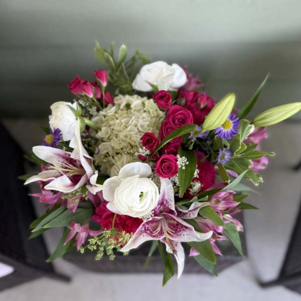 Bouquet of pink roses, white lilies, and purple daisies