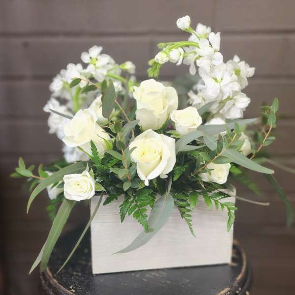 White roses and white blossoms in a rectangular box arrangement