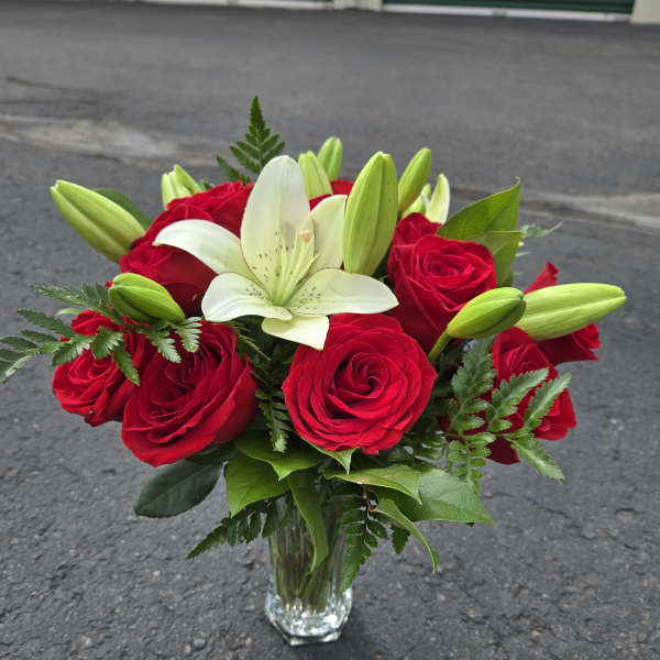 Red roses and white lilies in a clear glass vase