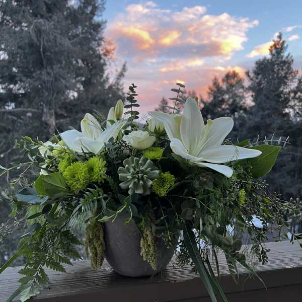 White lilies and green blooms in a gray vase