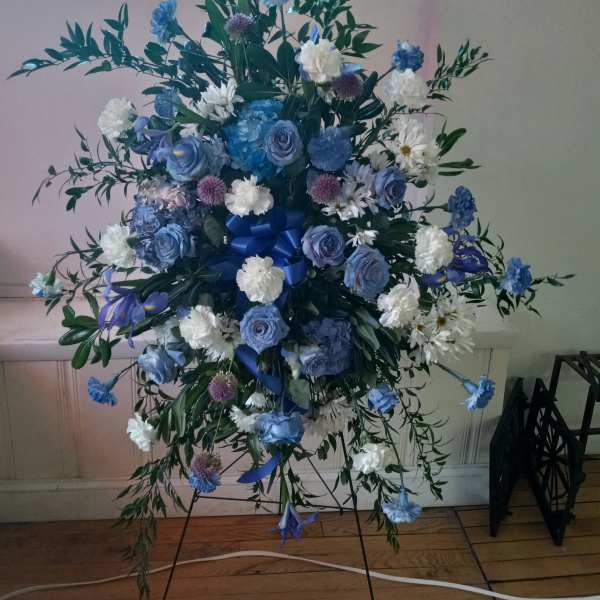 Blue and white floral standing spray on an easel