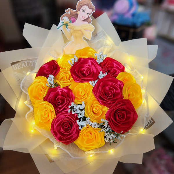 Bouquet of red and yellow roses with a Belle topper and lights