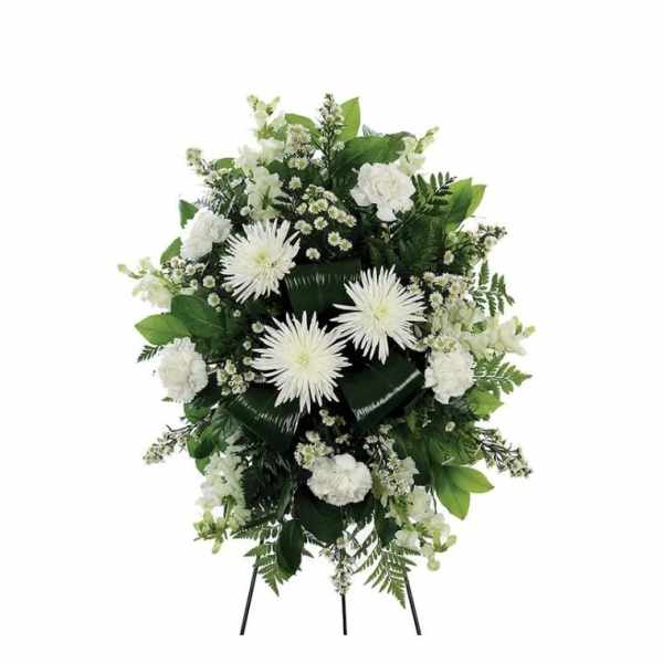 White floral standing spray with daisies and carnations on a black easel