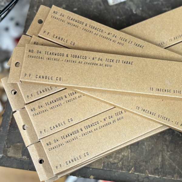 Stack of P.F. Candle Co. incense boxes labeled Teakwood & Tobacco