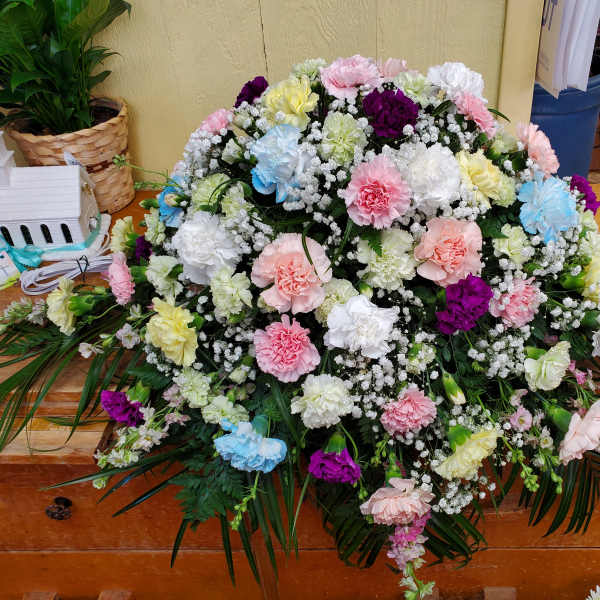 Large casket spray of pastel carnations with baby's breath