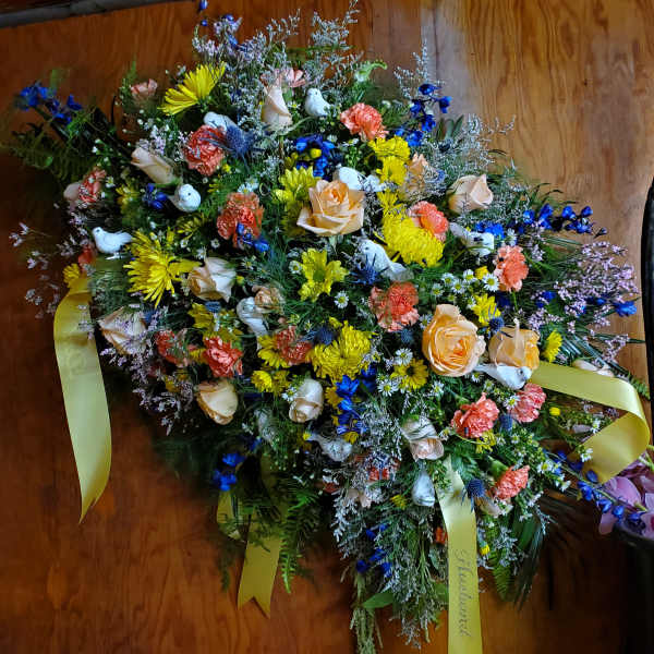 Large mixed floral spray with yellow ribbons and white doves