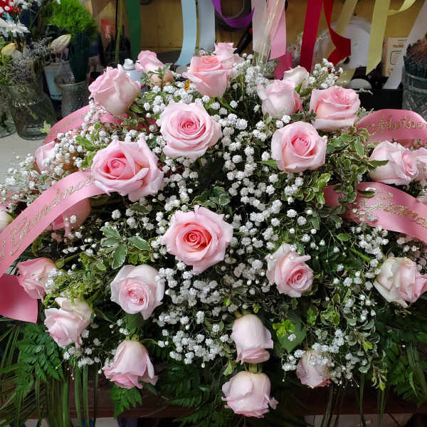 Large pink rose arrangement with baby’s breath and pink ribbons