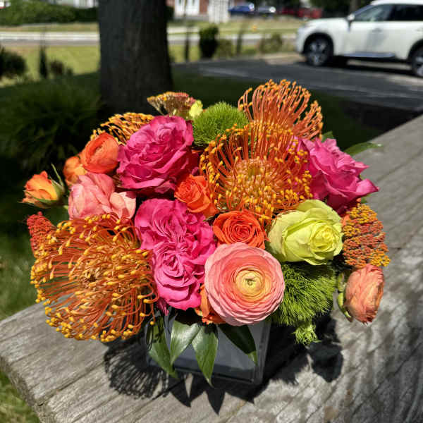 Bright mixed bouquet of pink, orange, and green flowers in a vase
