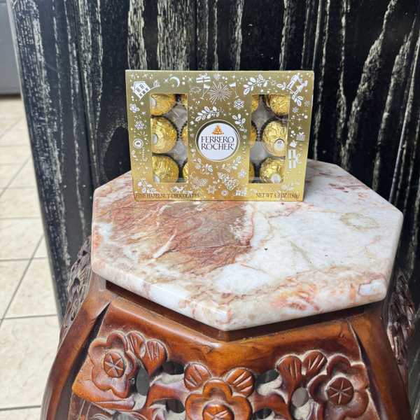 Box of Ferrero Rocher chocolates on a decorative stool